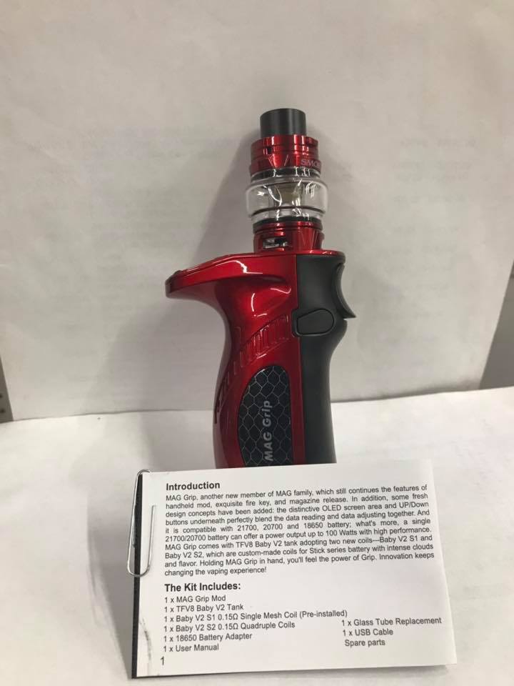 Red vape device with black grip. Info card lists kit contents, including tank and coils. 100 watt output.